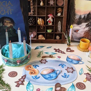 May include: A table setting for a Lucia celebration with a blue and green candle holder, a blue and white plate with a cup of coffee, and a variety of Swedish Christmas decorations, including gingerbread cookies, cinnamon buns, and a small wooden horse.