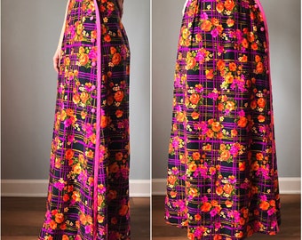 May include: A long, black skirt with a pink and orange floral print. The skirt has a side zipper and a pink trim.
