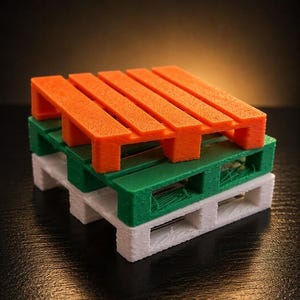 May include: A stack of three miniature shipping pallets, each featuring a distinct color. The top pallet is bright orange, the middle pallet is forest green, and the bottom pallet is white. Each pallet has a slatted top surface and support blocks.