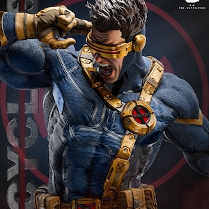 Op de afbeelding: Een gedetailleerd 1/6 schaal verzamelbeeldje van Cyclops met een blauw tactisch pak met textuur, een gouden harnas en een gereedschapsriem. Het personage draagt een kenmerkend rood vizier over de ogen, heeft bruin haar en een hand bij het hoofd.