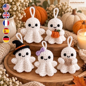 May include: Five white crocheted ghost ornaments with black bead eyes and stitched smiles. One ghost wears a black witch hat with an orange band, one holds a small orange pumpkin, one has a purple bow, one holds a brown heart, and one is plain.