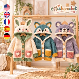 May include: Three crocheted hooded cardigans hanging on wooden hangers. The left is cream with green trim and bunny ears. The center is teal with yellow pockets and fox ears. The right is purple with pink pockets and bear ears. All feature wooden buttons.