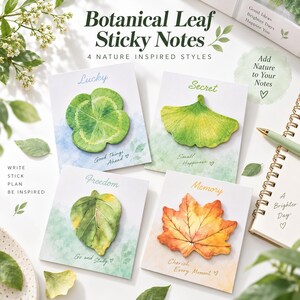May include: Four square cards featuring botanical leaf sticky notes in clover, ginkgo, rounded, and maple shapes. Each card displays text including Lucky, Secret, Freedom, and Memory, along with phrases like Good Things Ahead and Cherish Every Moment.
