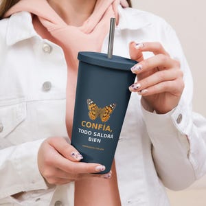 Puede incluir: Un vaso azul oscuro con tapa y pajita de metal. El vaso presenta un gráfico de una mariposa marrón y naranja sobre el texto "CONFÍA, TODO SALDRÁ BIEN" en amarillo y blanco, con "ENFERMERIA CON JOSI" en texto amarillo más pequeño debajo.
