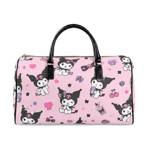 May include: A light pink duffel bag featuring an all-over print of the character Kuromi in various poses, interspersed with small purple skulls, pink hearts, cherries, and bows. The bag has black handles and a black zipper along the top edge.