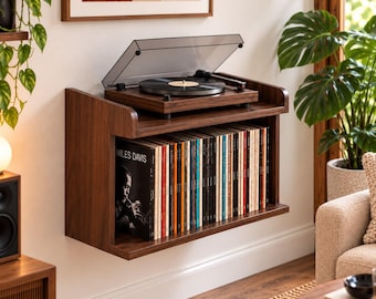 May include: A wall-mounted dark wood record player console featuring a top surface holding a turntable with a clear dust cover and a lower shelf filled with a collection of vinyl records, including one clearly labeled Miles Davis.