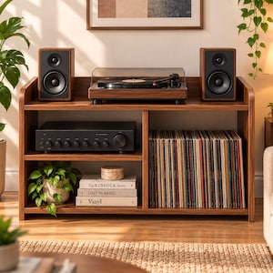 May include: A wooden media console featuring a turntable on the top shelf, two speakers, an amplifier, and a collection of vinyl records. The bottom shelf holds three stacked books titled The Kinfolk Home, Lost in Music, and Vinyl.