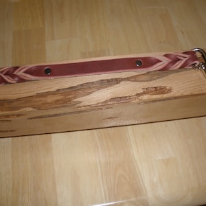 May include: A braided leather dog leash with two silver clips. The leash is brown with a light brown braid.