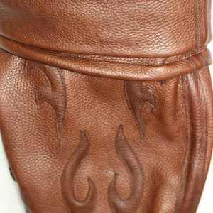 May include: Brown leather boot with a flame design. The boot has a fold-over top and a pointed toe.