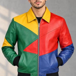 May include: A color-blocked leather jacket featuring a vibrant geometric pattern in primary colors including red, yellow, green, and blue. The jacket has a classic collar, a central silver zipper, and black ribbed cuffs and hem at the waist.