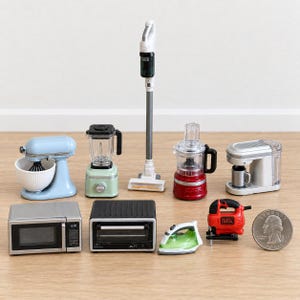Könnte beinhalten: Eine Sammlung von Miniatur-Haushaltsgeräten, darunter ein hellblauer Standmixer, ein grüner Mixer, ein weißer Stabstaubsauger, eine rote Küchenmaschine, eine weiße Kaffeemaschine, eine silberne Mikrowelle, ein schwarzer Toaster, ein grünes Bügeleisen und eine rote Stichsäge neben einer US-Münze.