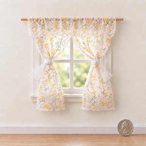 May include: A miniature window curtain set featuring a delicate white lace fabric with a yellow floral pattern. The curtains are hung on a wooden rod and gathered with matching lace ties. A coin is placed nearby for scale reference.