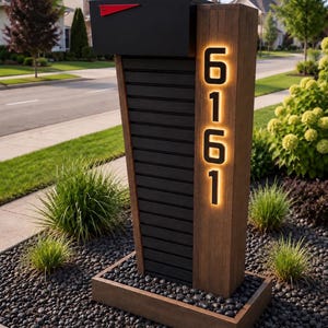 May include: A modern mailbox featuring a black metal box with a red flag, mounted on a vertical wooden post. The post displays the illuminated house numbers 6161 in a vertical orientation, set against a dark, slatted panel base.