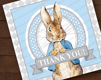 Puede incluir: Tarjeta cuadrada con una ilustración en acuarela de Peter Rabbit con una chaqueta azul. La tarjeta tiene un fondo azul claro con una pancarta gris que dice "THANK YOU!". El diseño incluye un patrón de diamantes grises y blancos.