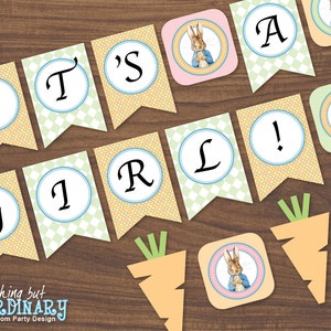 May include: A banner with the words "It's a Girl!" in yellow and green circles with a checkered background. There are also images of Peter Rabbit and carrots.