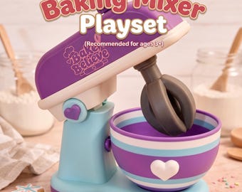 May include: A purple and light blue toy baking mixer playset with a mixing bowl featuring a white heart. The mixer is labeled Baking Mixer Playset and Bake Believe with a recommended age of 3+. It includes a dark gray whisk attachment.