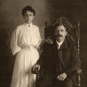 Download digital de foto vintage - casal vitoriano apaixonado, jovem de óculos em pé com bigode, homem sentado, retrato de estúdio