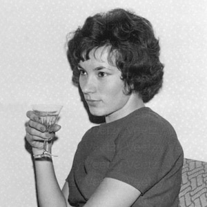 Photo vintage à téléchargement numérique - jeune femme des années 50 et 60, assise sur une chaise et buvant du vin ou du champagne lors d'une fête instantanée