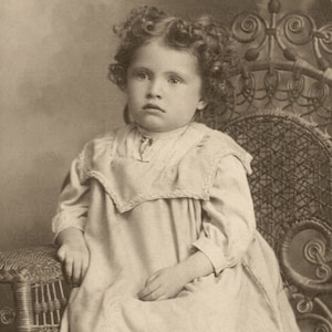 Digitale download vintage foto - Victoriaans meisje met prachtig krullend haar zittend in een rieten stoel Studioportret