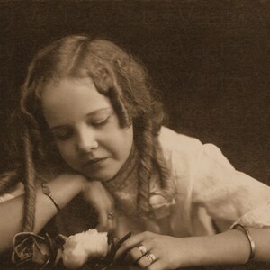 Digitale download vintage foto - Victoriaans meisje met mooie krullen die liefdevol glimlachen en een roos ruiken terwijl ze droomt Studioportret