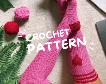 May include: A crochet pattern for heart socks. The pattern includes instructions for making pink socks with red hearts. The image shows a pair of pink socks with red hearts on the legs. The text "CROCHET PATTERN" is written in white on a black background.