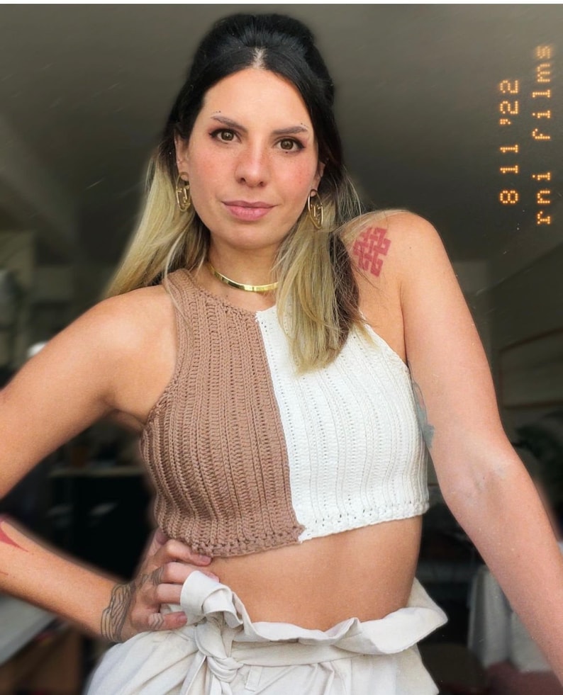 May include: A brown and white crocheted halter top with a contrasting color design. The top is cropped and has a relaxed fit.