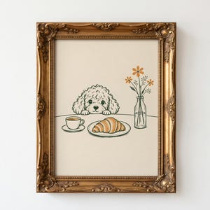 Könnte beinhalten: Eine gerahmte Illustration mit einem lockigen Hund, der über einen Tisch schaut, auf dem eine Tasse Kaffee, ein Croissant auf einem Teller und eine kleine Glasvase mit orangefarbenen Blumen stehen. Das Bild hat einen verzierten Goldrahmen.