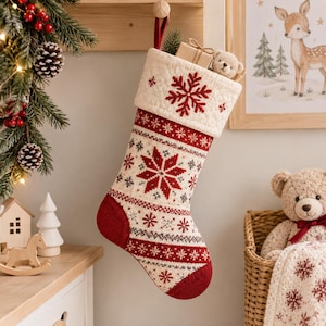Puede incluir: Un calcetín navideño de color crema con un puño acolchado y un copo de nieve rojo bordado. El cuerpo presenta un patrón nórdico en rojo y gris con motivos de copos de nieve, un talón rojo sólido y una puntera de color rojo.