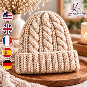 May include: A beige knit beanie featuring a prominent vertical cable knit pattern on the crown and a thick, ribbed folded brim. The hat is crafted from a solid light tan yarn, showcasing a textured, chunky stitch design throughout the entire piece.