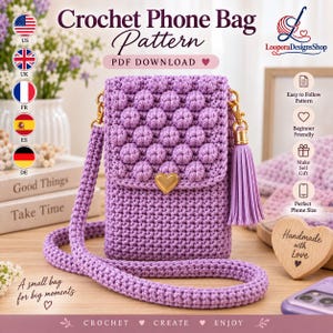 May include: A lavender crochet phone bag featuring a textured bobble stitch flap, a gold heart-shaped clasp, and a matching tassel. The bag includes a long crossbody strap. Text on the image reads: Crochet Phone Bag Pattern, PDF DOWNLOAD.