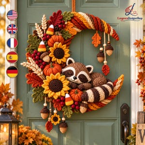 Puede incluir: Una corona de ganchillo en forma de media luna con un mapache durmiente, girasoles, calabazas, dulces de maíz y hojas de otoño en tonos naranja, amarillo, marrón y rojo, con adornos colgantes de bellotas y hojas sobre una puerta verde.