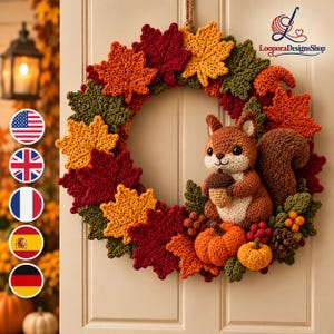 May include: A crochet wreath featuring autumn-coloured maple leaves in red, orange, yellow, and green. A brown squirrel holding an acorn is attached to the side, accompanied by two orange pumpkins, small red berries, and a brown pinecone.