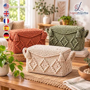May include: Three rectangular storage baskets with lids, crafted from thick yarn in cream, sage green, and terracotta orange. Each basket features a textured diamond pattern, side handles, and decorative tassels on the front corners of the lid.