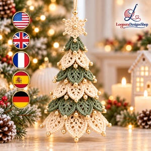 May include: A crocheted Christmas tree ornament featuring alternating layers of cream and sage green leaf-shaped motifs. The tree is topped with a crocheted snowflake and embellished with small, shiny gold beads throughout the structure.
