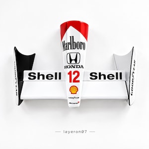May include: A Formula 1 rear wing replica featuring a white and red color scheme with the number 12. The design includes branding for Marlboro, Honda, Shell, Goodyear, and McLaren. The structure is white with black endplates and text.