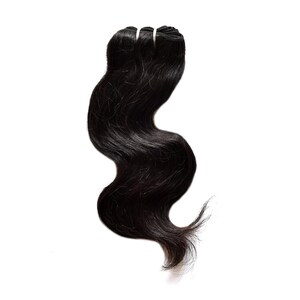 Puede incluir: Un paquete de extensiones de cabello negro, largo y ondulado, con una trama reforzada en la parte superior. El cabello tiene una textura natural y brillante con un patrón de ondas suaves que fluye hacia abajo, terminando en puntas finas.
