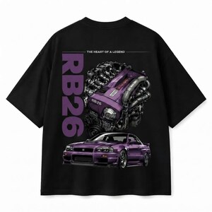 Könnte beinhalten: Ein schwarzes Kurzarm-T-Shirt mit einem Grafikdruck auf der Rückseite. Das Design zeigt einen violetten RB26-Motor über einem violetten Sportwagen, mit dem Text "RB26" in großen violetten Buchstaben und "THE HEART OF A LEGEND" in weiß.