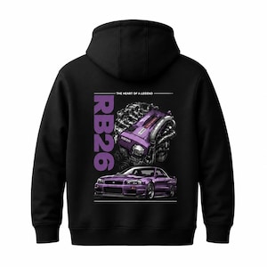 Può includere: Una felpa con cappuccio nera con una grafica sul retro. Il design include un'illustrazione del motore RB26 viola, un'auto sportiva viola e il testo "RB26" e "THE HEART OF A LEGEND" stampati in bianco e viola su uno sfondo nero.