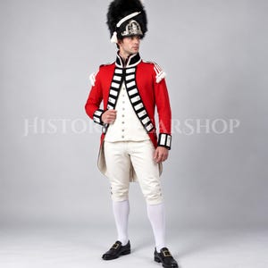 May include: A historical military uniform featuring a bright red tailcoat with black and white trim, a white waistcoat, white breeches, and white stockings. The ensemble includes a tall black bearskin hat with a silver plate and white cord.