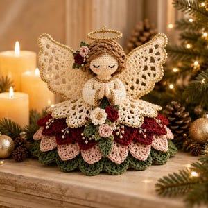 A crochet angel ornament sits on a mantelpiece in front of glowing candles and a decorated Christmas tree.