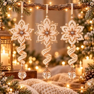 May include: Three hanging ornaments featuring cream-colored lace flower motifs with central clear crystals, accented by small pearls. Each ornament includes a spiraling lace tail ending in a faceted clear glass sphere with a gold-toned cap.