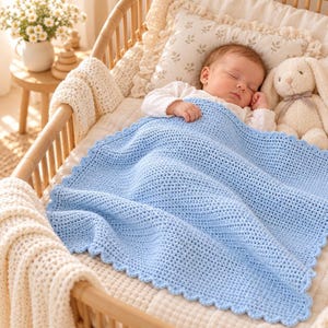 May include: A light blue crochet baby blanket with a scalloped edge, covering a sleeping infant who is wearing a white long-sleeved shirt. The blanket features a dense, textured stitch pattern and is draped over the infant in a wooden crib.