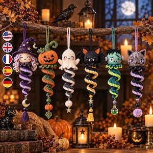 May include: Six crocheted Halloween ornaments hanging from a branch, featuring a witch, a pumpkin, a ghost, a bat, a Frankenstein monster, and a cat. Each figure has a spiral tail, decorative charms, and a hanging loop for seasonal display.