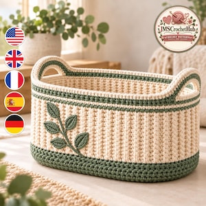 Puede incluir: Una cesta de ganchillo de forma ovalada en hilo color crema y verde salvia. La cesta presenta un cuerpo de color crema acanalado, una base de color verde salvia sólido y un borde verde a juego con asas integradas. Un motivo decorativo de hoja verde salvia está cosido en el lateral.