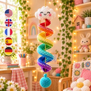 May include: A crocheted hanging decoration featuring a white cloud with a smiling face and pink cheeks at the top, connected to a long, spiraling rainbow-colored tail adorned with small white beads, ending in a bright blue textured pom-pom.