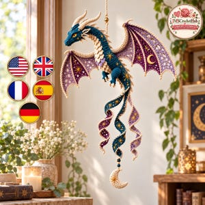 May include: A hanging crochet dragon ornament featuring deep blue and purple yarn with cream-colored accents. The dragon has intricate wings decorated with gold star and moon embroidery, a long curled tail, and a dangling crescent moon charm.