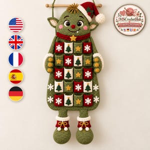 Könnte beinhalten: Ein gehäkelter Adventskalender zum Aufhängen in Form eines grünen Elfen mit einer rot-weißen Weihnachtsmannmütze. Der Elf hat vierundzwanzig kleine Taschen, die mit weißen Schneeflocken, grünen Tannenbäumen und gelben Sternen auf rotem und weißem Grund verziert sind.