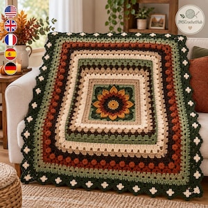 Könnte beinhalten: Eine quadratische Häkeldecke mit einem zentralen Sonnenblumenmotiv in Gelb, Orange und Dunkelbraun. Das Design umfasst konzentrische quadratische Ränder in Creme, Beige, Olivgrün und Rostbraun, abgeschlossen mit einem gewellten Rand in Creme und Dunkelgrün.