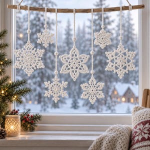 May include: A wall hanging featuring seven white crocheted snowflake ornaments of varying sizes suspended from a horizontal wooden branch by thin white cords. Each snowflake displays intricate lace-like patterns and is attached to the branch.