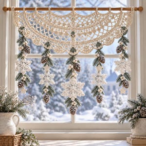 May include: A cream-coloured crocheted window valance featuring an intricate lace pattern. Five vertical strands hang from the valance, each decorated with crocheted snowflakes, small stars, green pine needles, white berries, and brown pinecones.